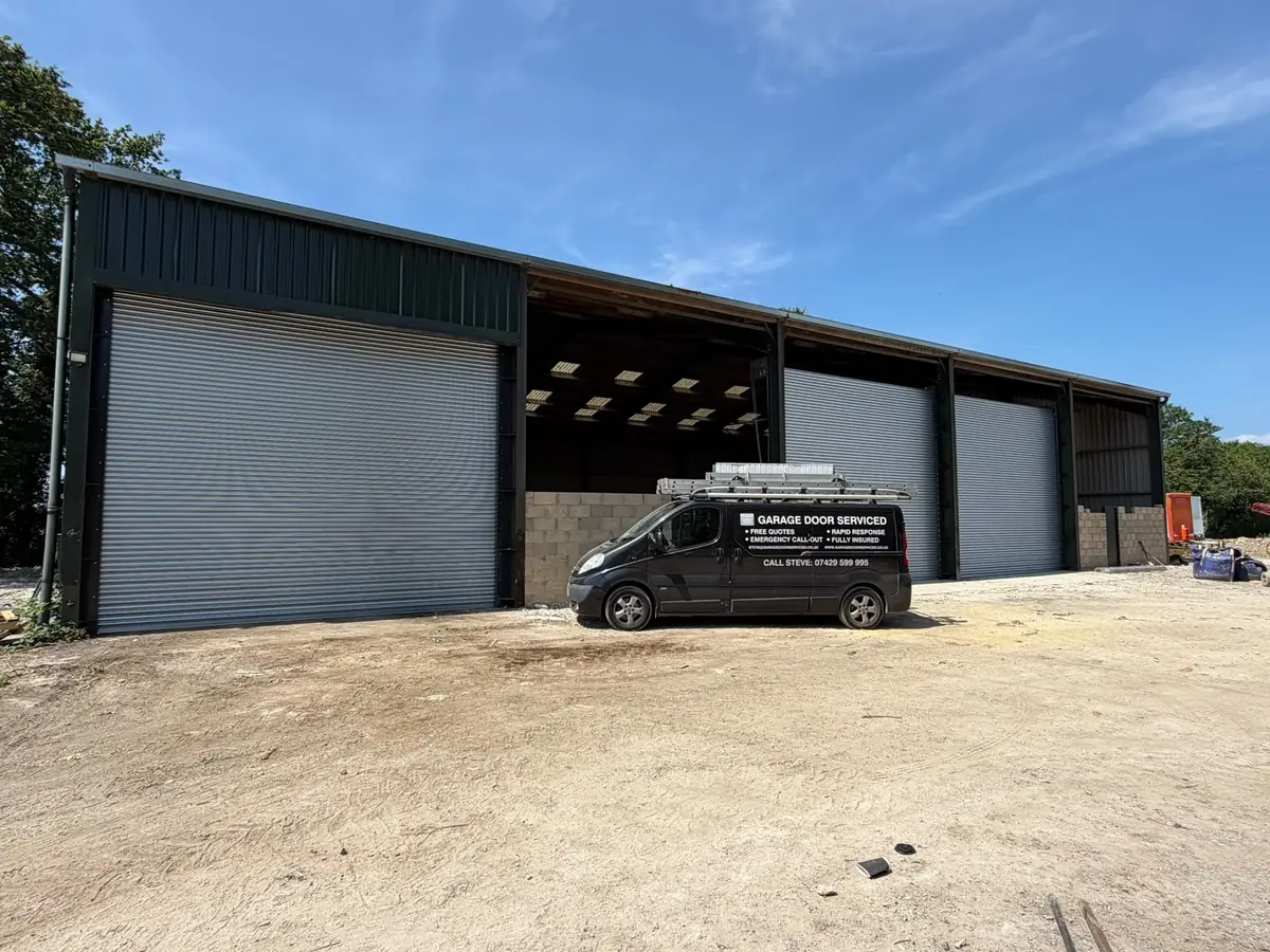 Garage Door Serviced van in front of a barn fitted with large roller shutters