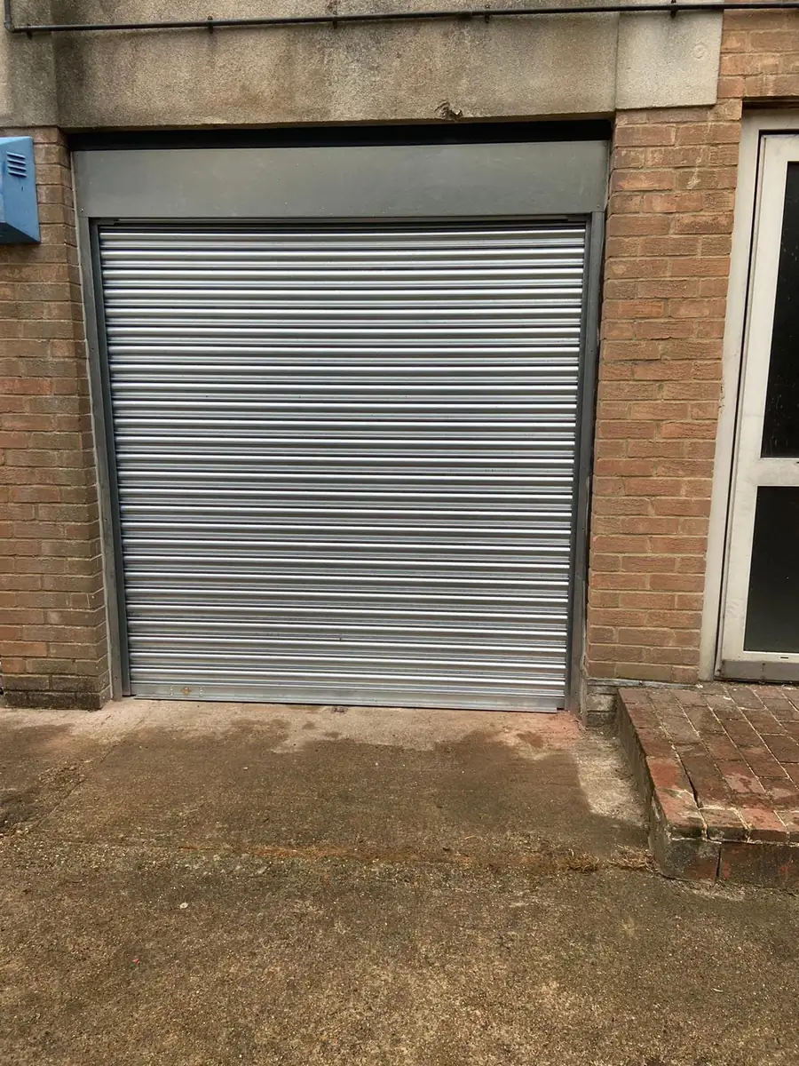 Galvanised roller shutter fitted into a brick opening