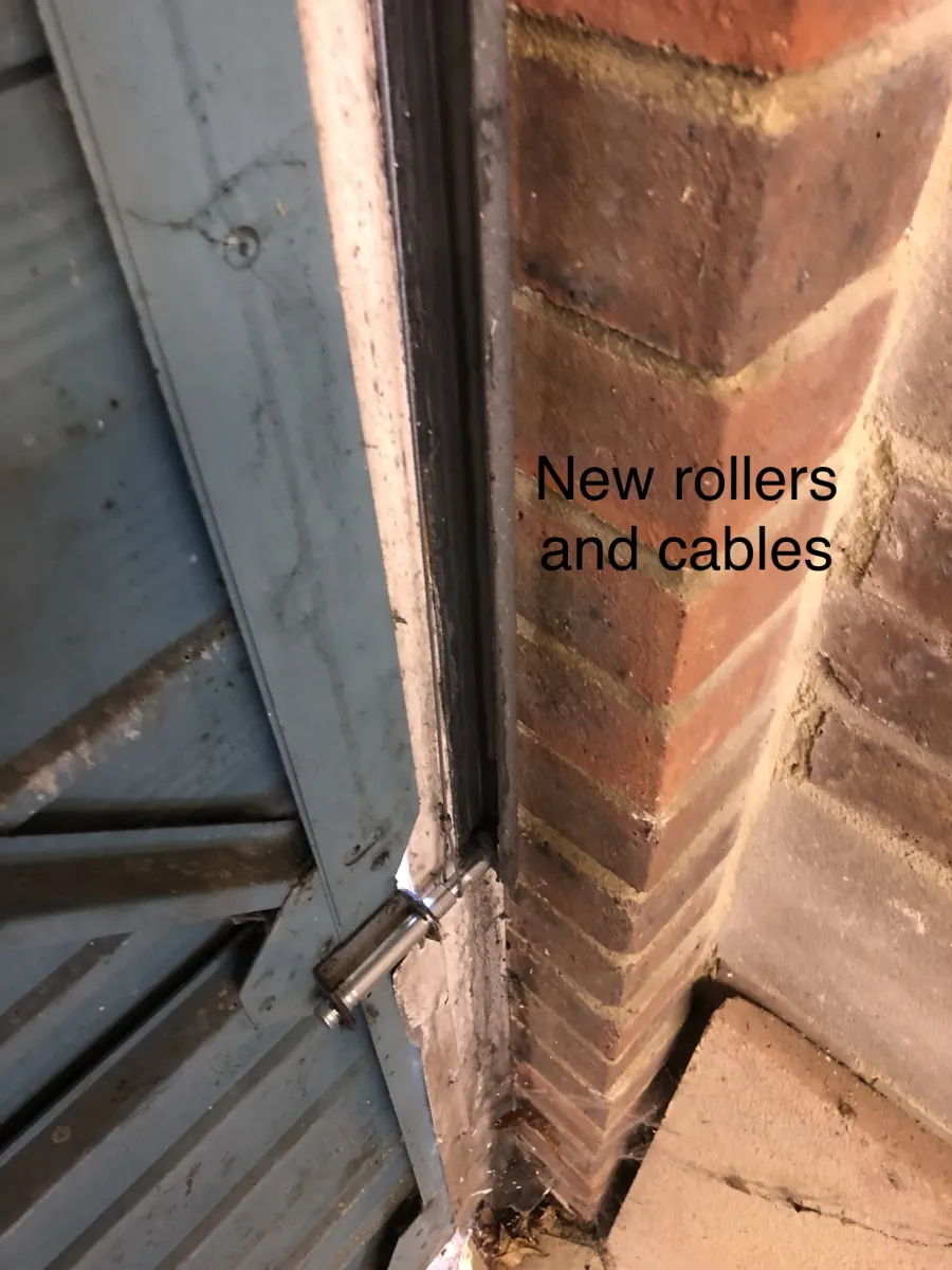 Close-up of new rollers and cables fitted during a garage door service