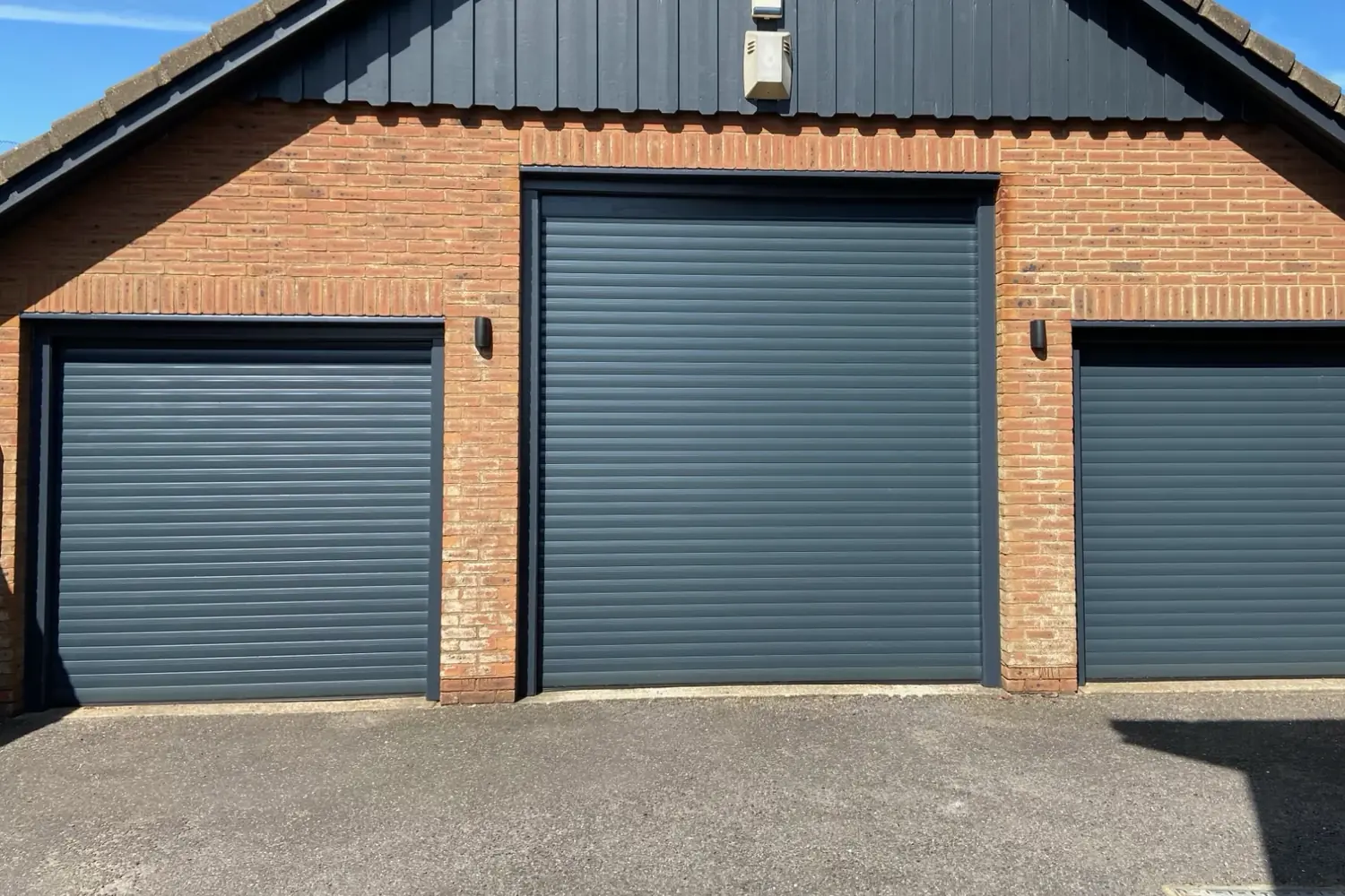 The same garage with three new anthracite grey roller doors